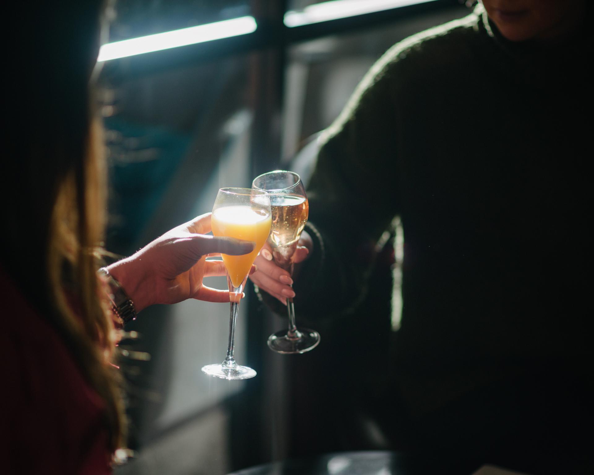 Two lounge guests toasting their journey with a runway view